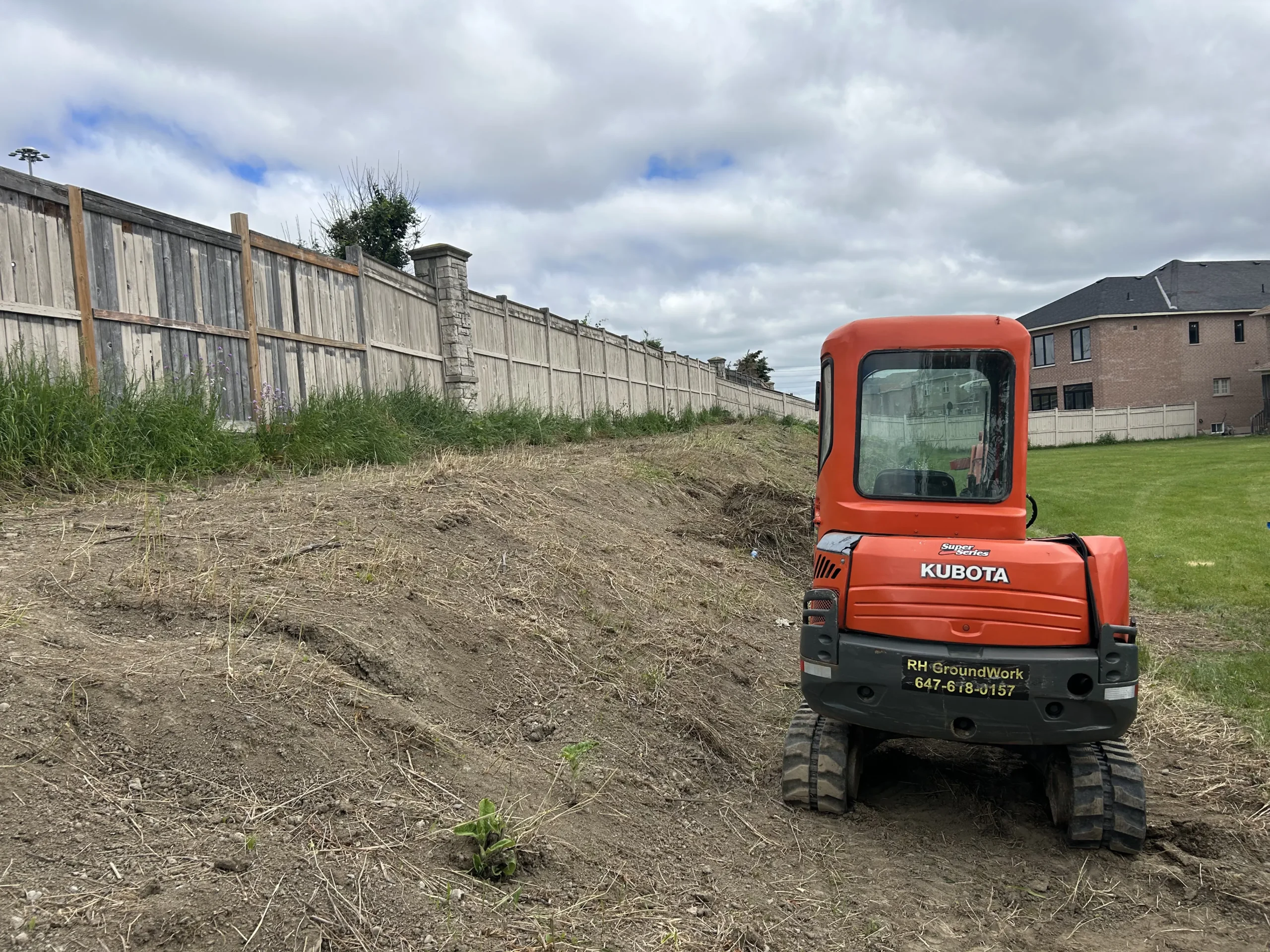 Mini excavator performing land clearing and site preparation for a residential construction project in Richmond Hill, Ontario by RHGroundwork.
